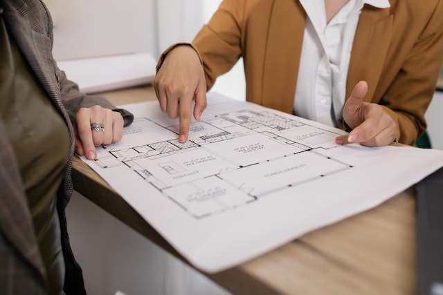 a property manager and property owner looking over a homes blueprints